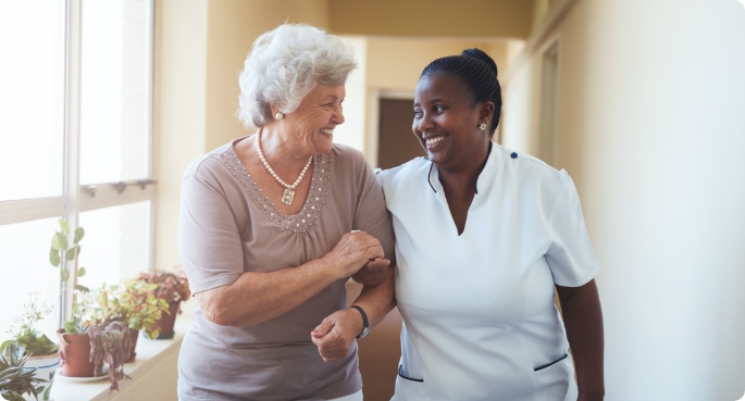 Smiling home caregiver and senior woman